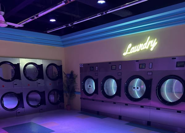 A purple-hued laundry room emulating the recurring set featured in many K-pop music videos